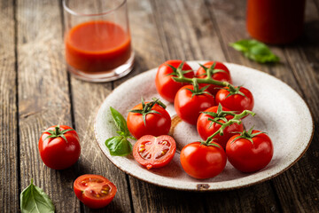 Fresh tomatoes in a plate with basil leaves preparing for the preservation on old wooden table. Organic food.