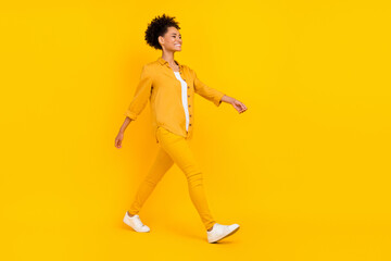 Full length body size photo woman smiling wslking forward isolated bright yellow color background