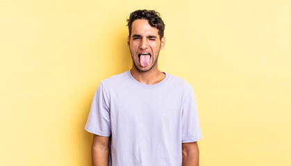 hispanic handsome man with cheerful and rebellious attitude, joking and sticking tongue out