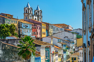 Fototapeta na wymiar Colorful houses facades and historic church towers in baroque and colonial style with blue sky in the famous Pelourinho neighborhood of Salvador, Bahia