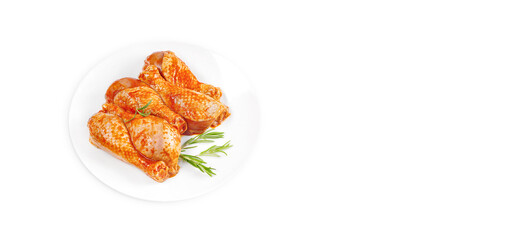 Baner.Cooking chicken drumsticks.Raw chicken legs in a marinade with rosemary on a background.Marinated chicken dramstick with spices for cooking.Top view, copy space.Isolated