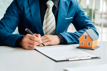 Buying a Home or Insurance, an insurance agent explains the lease agreement to a client before...