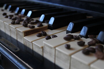 Fototapeta na wymiar coffee beans on the piano. coffee beans lie beautifully on the piano keyboard. coffee and piano