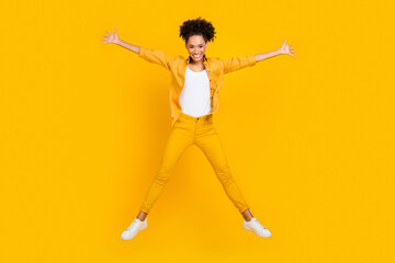 Fototapeta na wymiar Full length body size photo woman jumping up playful happy isolated vivid yellow color background