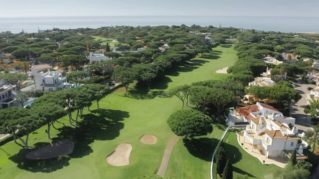 Drone flying over Vale de Lobo beachfront resort in the Algarve, Portugal, Europe. Aerial shot of private houses located on coast of Atlantic ocean. Summer landscape with seascape, 4k footage