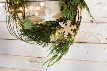 Christmas decoration with pine wreath on white vintage planks and luminous bokeh. Background for...