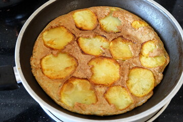 Sliced Spanish potato omelette in pan, selective focus. Potato Egg and Onion Omelette known locally as an Spanish Tortilla. It is called 