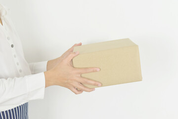 Obraz premium Woman hand holding cardboard box on white background.