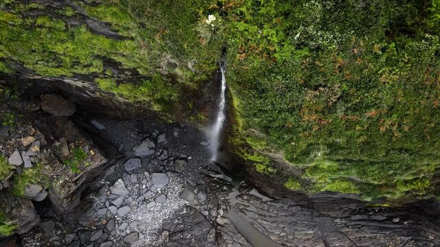 Waterfall spills down steep seacliffs on Basque Country coastline, Spain. High quality 4k footage