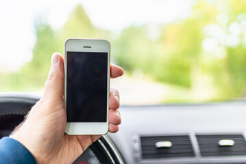 Man hand holding screen smart phone, blur on the road high way forest summer background.copy space,advertisement,banner.