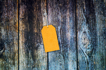 Blank gift label mockup with copy space pinned on a vintage wooden background.