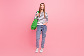 Full length body size view of attractive cheerful girl shopping carrying eco bag isolated over pink pastel color background