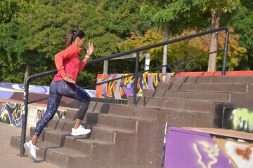 Young latin woman running on urban scene scale.