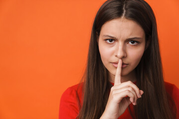 Fototapeta premium Young white brunette woman showing silence gesture at camera