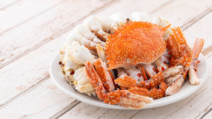 steamed crabs in white ceramic plate on white old wood texture background with copy space for text,...