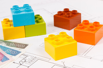 Obraz premium Colorful toy blocks, polish banknote and construction drawings of house. Buying or renting home concept