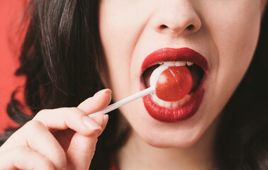 Image of a beautiful woman eating a fruity lollypop