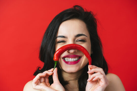 Image of beautiful woman having fun with a red chili pepper