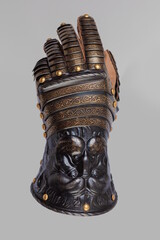 Medieval knightly brown plate gauntlet from Italian armor, in the form of a lion's face and mane,...
