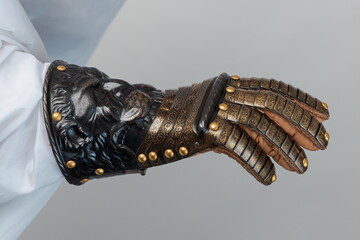 Medieval knightly brown plate gauntlet from Italian armor, in the form of a lion's face and mane,...
