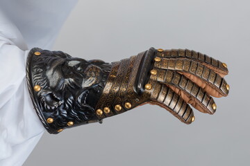 Medieval knightly brown plate gauntlet from Italian armor, in the form of a lion's face and mane,...