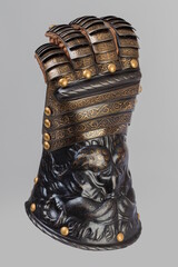Medieval knightly brown plate gauntlet from Italian armor, in the form of a lion's face and mane,...