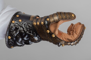 Medieval knightly brown plate gauntlet from Italian armor, in the form of a lion's face and mane,...