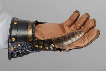 Medieval knightly brown plate gauntlet from Italian armor, in the form of a lion's face and mane,...