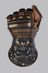 Medieval knightly brown plate gauntlet from Italian armor, in the form of a lion's face and mane,...