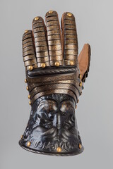 Medieval knightly brown plate gauntlet from Italian armor, in the form of a lion's face and mane,...