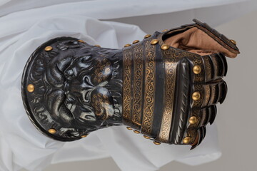 Medieval knightly brown plate gauntlet from Italian armor, in the form of a lion's face and mane,...