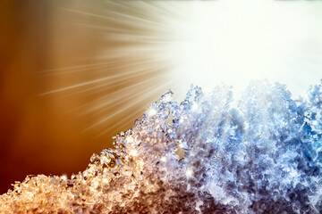 Natural snow texture with a gradient in the rays of the sun at sunset with beautiful rays. Close-up snow texture with creative gradient at sunset.