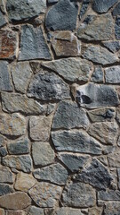 old stone wall made of dark gray brown stones background texture