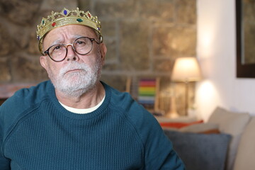 Spoiled senior man with brat expression wearing a crown