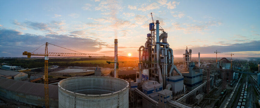 Aerial view of cement factory tower with high concrete plant structure at industrial production area. Manufacturing and global industry concept.