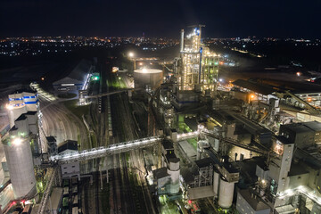 Aerial view of cement factory with high concrete plant structure and tower cranes at industrial...