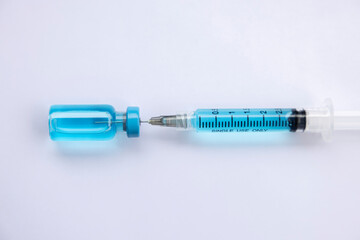 Close-up vials with vaccine and syringe for virus protection isolated on white background. Horizontal composition.