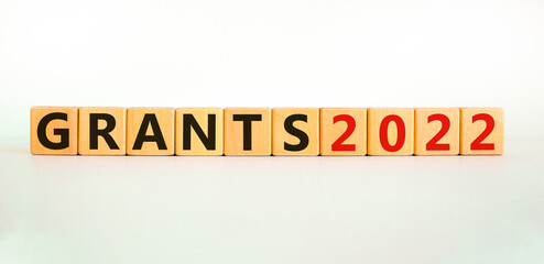 Business concept of grants planning 2022. Words 'Grants 2022' on wooden cubes. Beautiful white table, white background. Business and grants 2021 new year concept. Copy space.