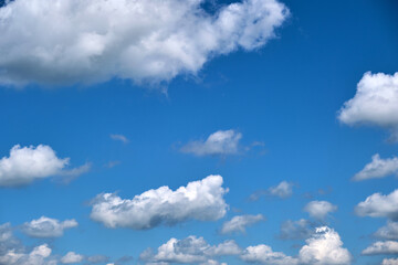 Obraz na płótnie Canvas Bright landscape of white puffy cumulus clouds on blue clear sky.
