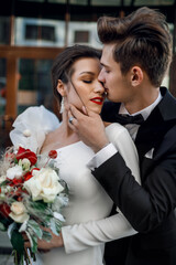 Portrait of a kissing woman and man. Bride and groom. Red lips