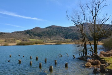a lake under hills overgrown with forest