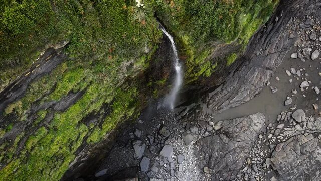 Waterfall spills down steep seacliffs on Basque Country coastline, Spain. High quality 4k footage