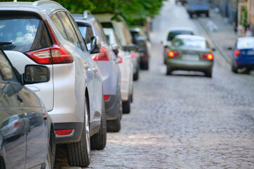 City traffic with cars parked in line on street side.