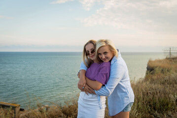 Mom hugs a teenage daughter at the top of the mountain. Sea Square. The concept of family, yoga, travel.