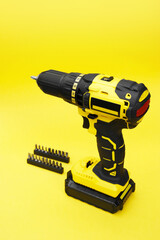 The yellow-black screwdriver on a yellow background, a set of bits.