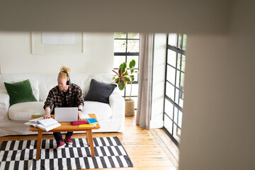 Albino african american man with dreadlocks working from home and making video call on the laptop