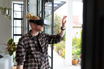 Albino african american man with dreadlocks working from home and using vr headsets