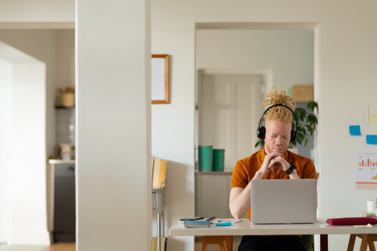 Albino african american man with dreadlocks working from home and making video call on the laptop