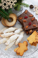 Assorted cookies, fir branches and a garland on a light background.