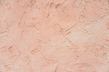 Close-up of a pink painted wall leaving an embossed cladding
